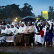 Catholic sisters wait just after dawn in the rain and mud to attend a mass given by Pope Francis.